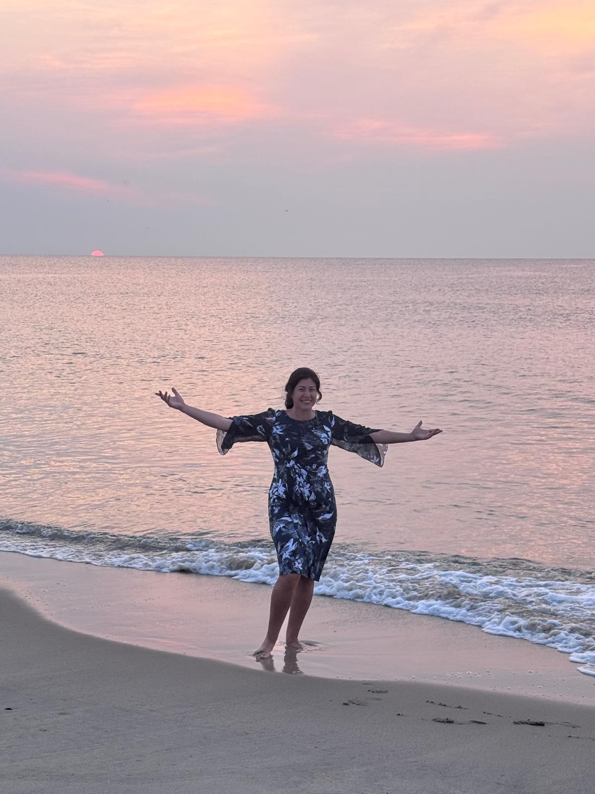 Suri Marozov standing by the ocean at sunrise